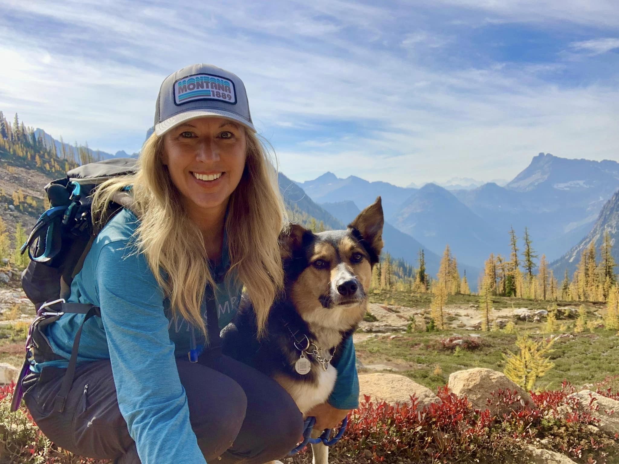 Women and shepard mix dog outside near mountains hiking. Dog is wearing a collar and PetHub tag